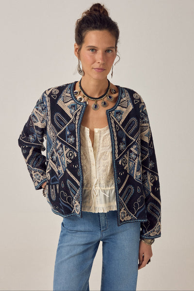 Maison Hotel Pati jacket in Blue Mosaic — cropped open-front indigo jacket fully embroidered in ivory and teal, styled over a top with jeans