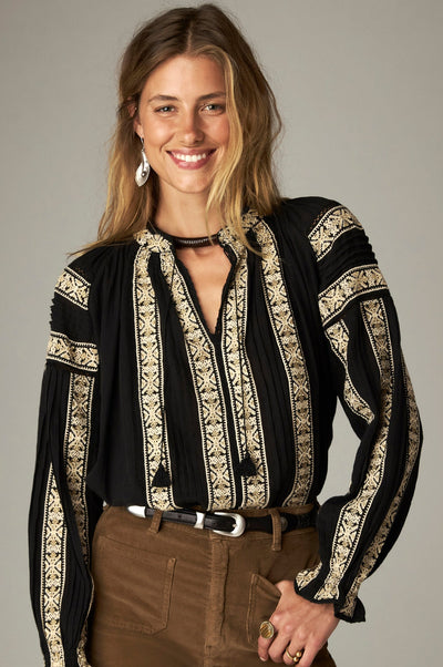 Rose Blouse in Noir, a cotton gauze blouse with tassel-tie split neckline and contrast embroidery on the front and sleeves